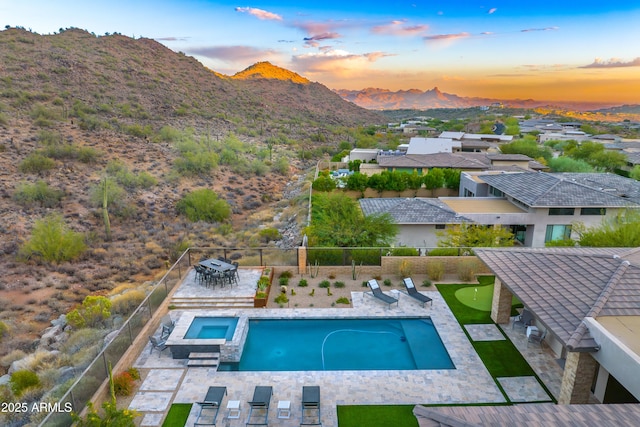 pool at dusk featuring a mountain view