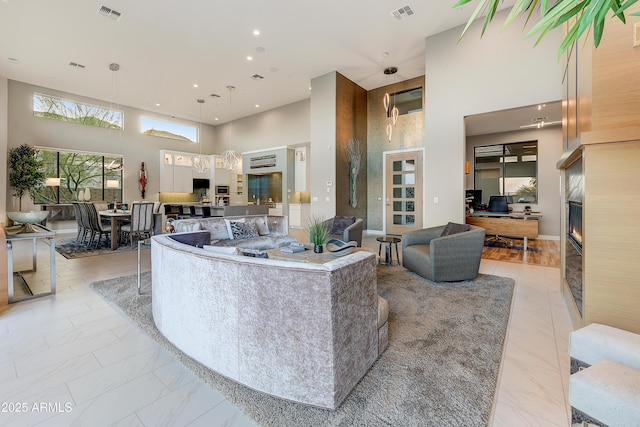 living room featuring a fireplace and a towering ceiling