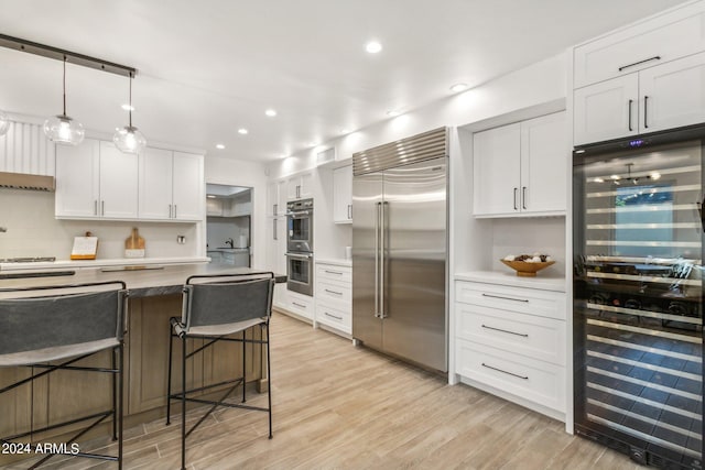 kitchen featuring white cabinetry, beverage cooler, stainless steel appliances, and light wood-type flooring