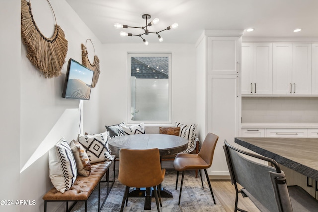 dining space with light wood-type flooring, an inviting chandelier, and breakfast area