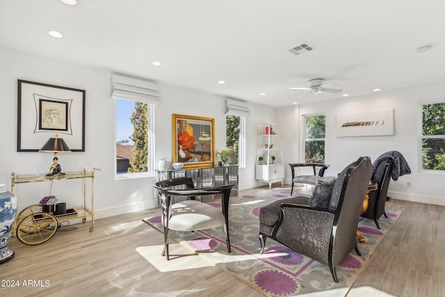 living room with light wood-type flooring, ceiling fan, and plenty of natural light