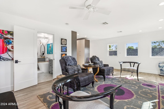 living room featuring ceiling fan and light hardwood / wood-style flooring