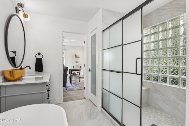 bathroom featuring shower with separate bathtub and vanity