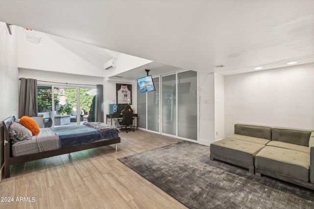 bedroom featuring a wall mounted air conditioner, hardwood / wood-style floors, and vaulted ceiling