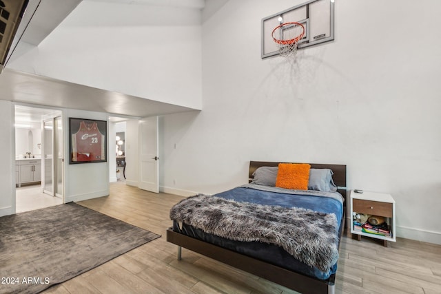 bedroom with wood-type flooring and connected bathroom