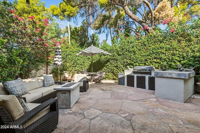 view of patio / terrace featuring exterior kitchen, grilling area, and an outdoor living space with a fire pit