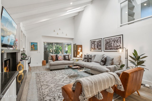 living room featuring beam ceiling, high vaulted ceiling, and light hardwood / wood-style flooring