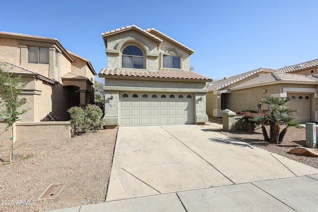 mediterranean / spanish house with an attached garage, a tiled roof, concrete driveway, and stucco siding