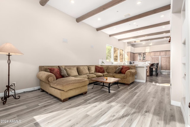 living room with beamed ceiling and light hardwood / wood-style flooring