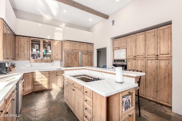 kitchen with a center island, a high ceiling, a kitchen breakfast bar, beamed ceiling, and stainless steel appliances