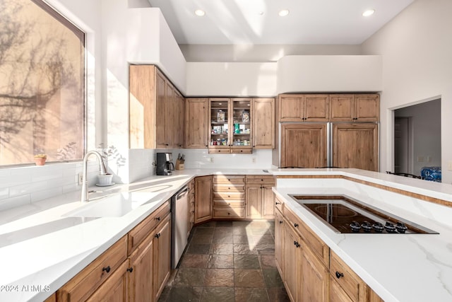 kitchen with backsplash, a high ceiling, black electric stovetop, sink, and stainless steel dishwasher