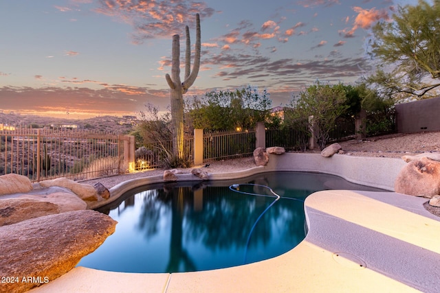 pool at dusk featuring a patio area