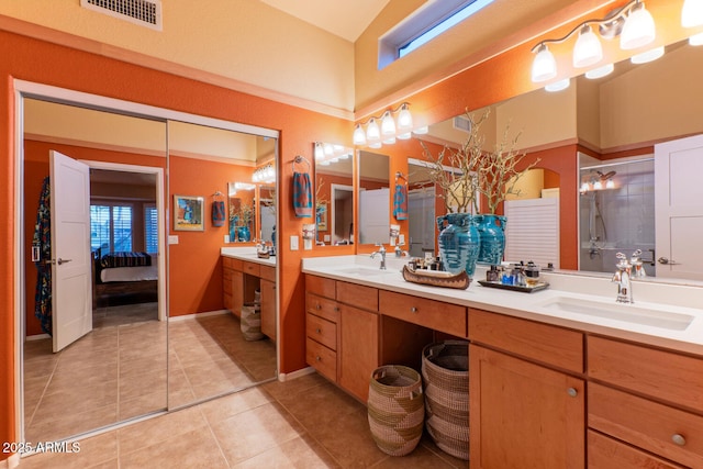 bathroom featuring tile patterned flooring, vanity, and walk in shower