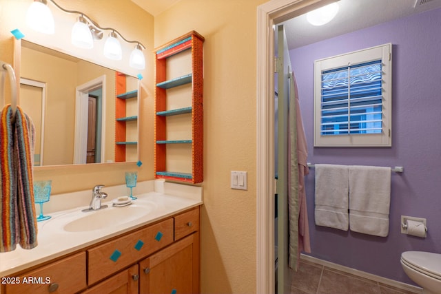 bathroom featuring tile patterned floors, vanity, and toilet