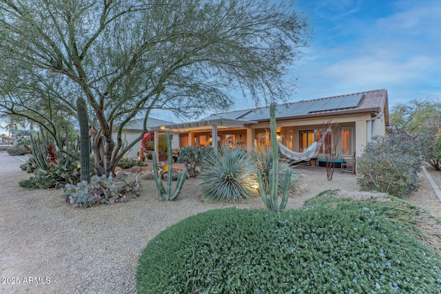 rear view of property featuring solar panels