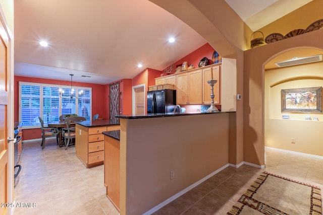 kitchen with black fridge, vaulted ceiling, pendant lighting, a chandelier, and light tile patterned flooring