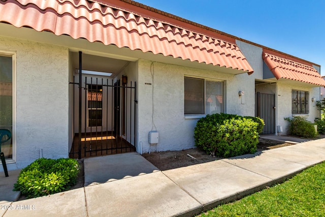 6818 N 35th Ave Unit C, Phoenix, AZ 85017 - entrance to property featuring a gate, stucco siding, and a tile roof