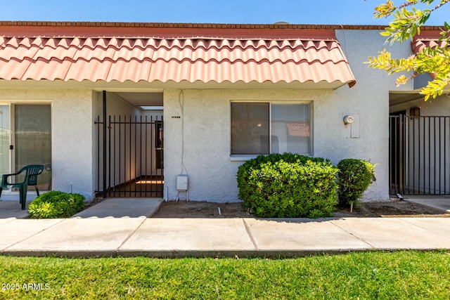 6818 N 35th Ave Unit C, Phoenix, AZ 85017 - view of front facade featuring stucco siding, a gate, and a tile roof