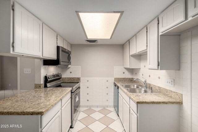 6818 N 35th Ave Unit C, Phoenix, AZ 85017 - kitchen featuring stainless steel appliances, a sink, tile walls, light countertops, and light tile patterned flooring
