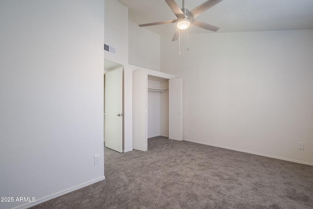 unfurnished bedroom with ceiling fan, carpet, and a high ceiling