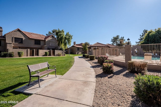 view of community with a patio area, a swimming pool, and a lawn