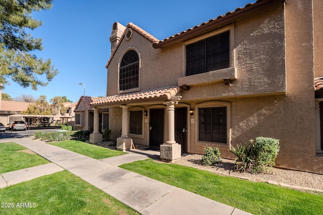 mediterranean / spanish home featuring a front lawn