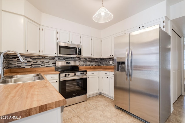 kitchen with white cabinetry, sink, hanging light fixtures, and appliances with stainless steel finishes