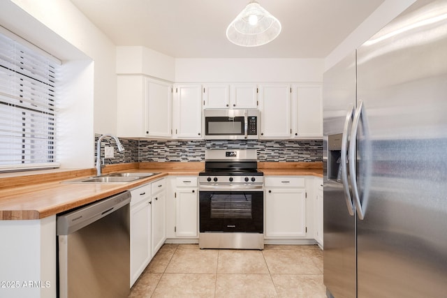 kitchen featuring pendant lighting, sink, white cabinetry, and stainless steel appliances