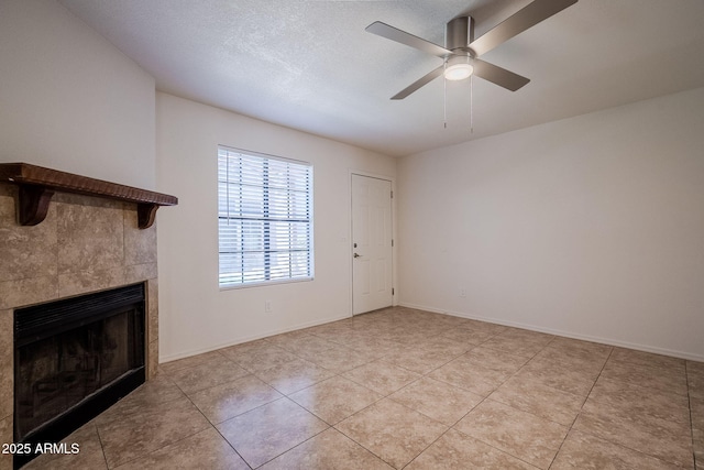 unfurnished living room with ceiling fan, light tile patterned floors, and a fireplace