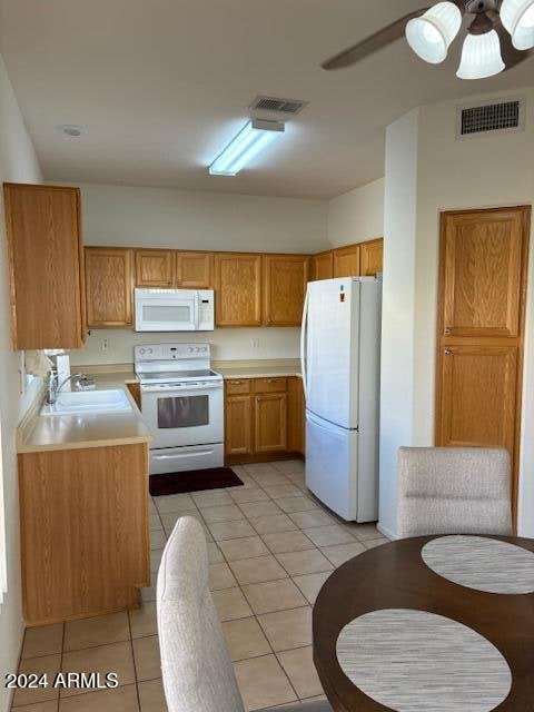 kitchen featuring white appliances, ceiling fan, light tile patterned floors, and sink