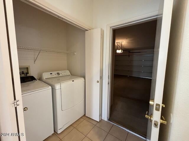 clothes washing area with washer and clothes dryer and light tile patterned floors