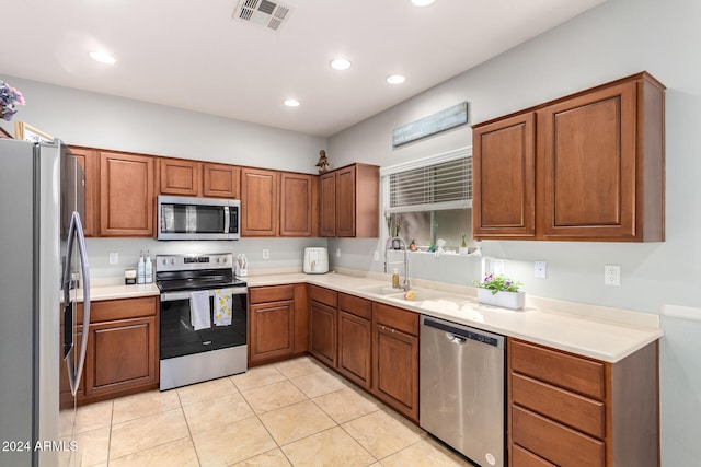 kitchen featuring light tile patterned flooring, stainless steel appliances, and sink