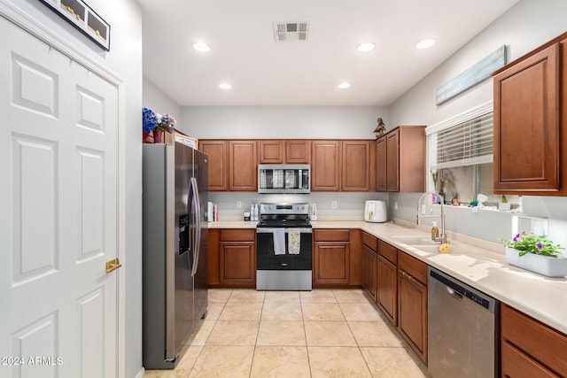 kitchen with sink, stainless steel appliances, and light tile patterned floors