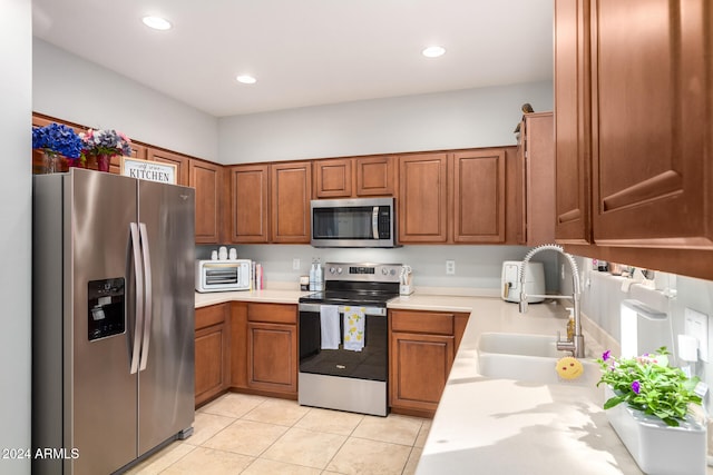 kitchen with light tile patterned floors, stainless steel appliances, and sink