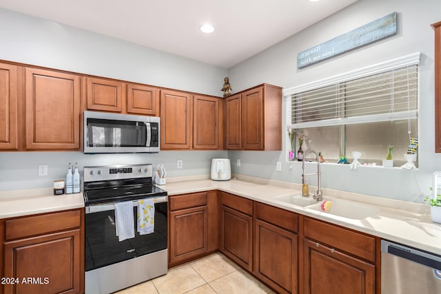 kitchen with sink, appliances with stainless steel finishes, and light tile patterned floors