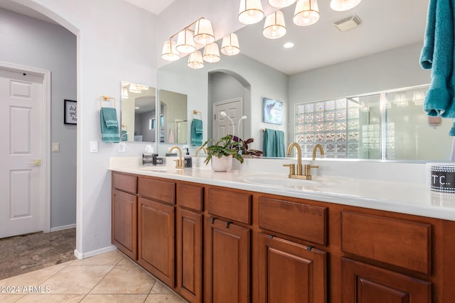 bathroom with vanity, a shower with door, a chandelier, and tile patterned flooring