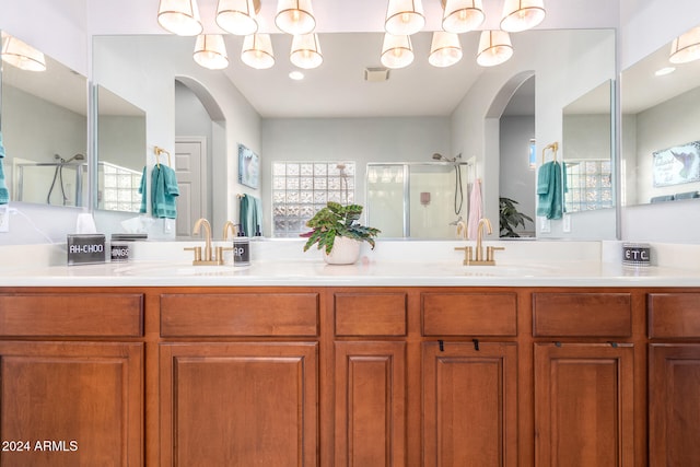 bathroom with a shower with door and vanity