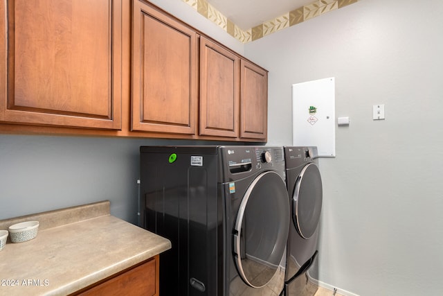 clothes washing area featuring cabinets and washing machine and clothes dryer