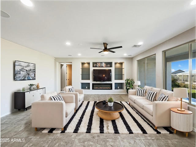 living area with built in shelves, recessed lighting, a ceiling fan, visible vents, and a glass covered fireplace