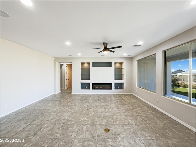 unfurnished living room with recessed lighting, visible vents, built in features, baseboards, and a glass covered fireplace