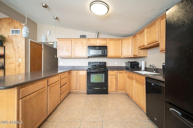 kitchen featuring black appliances, a sink, lofted ceiling, a peninsula, and dark countertops