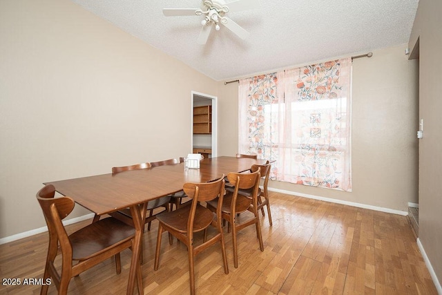 dining area with ceiling fan, a textured ceiling, baseboards, and light wood-type flooring