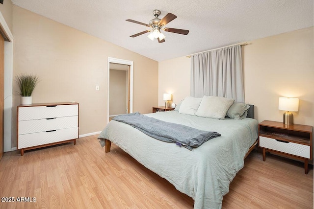 bedroom featuring lofted ceiling, light wood finished floors, ceiling fan, and baseboards
