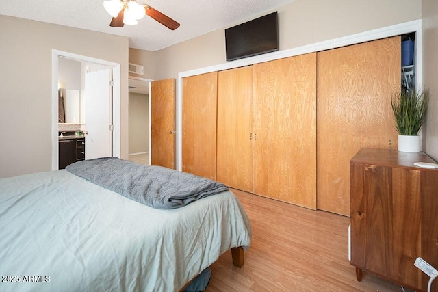 bedroom with wood finished floors, a closet, and a ceiling fan