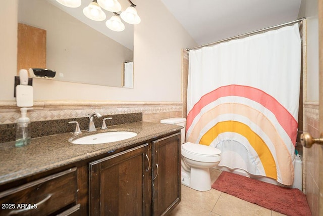 full bathroom with tile patterned flooring, vanity, toilet, tile walls, and a wainscoted wall
