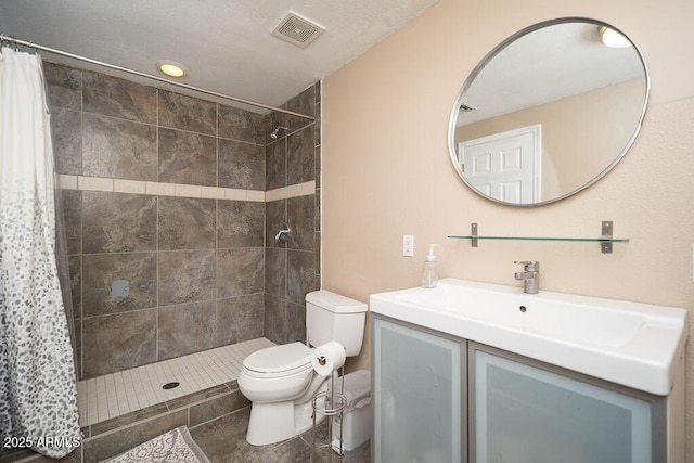 bathroom with tiled shower, toilet, vanity, and tile patterned floors