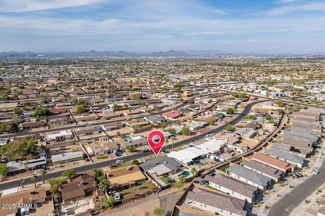 aerial view of property and surrounding area featuring a mountainous background and nearby suburban area