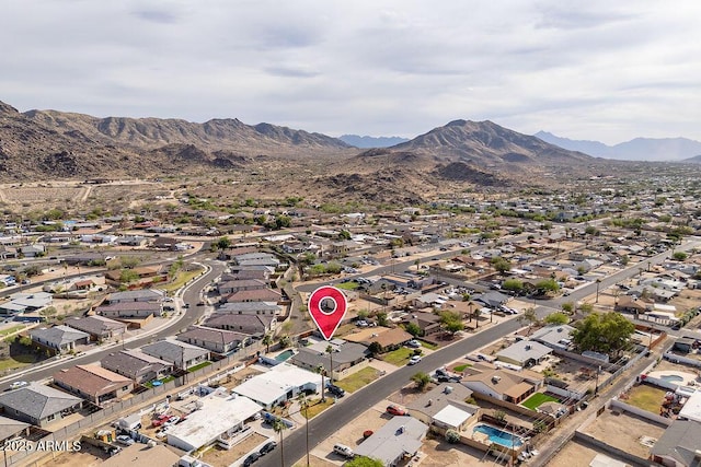 aerial view of property's location with nearby suburban area and a mountainous background