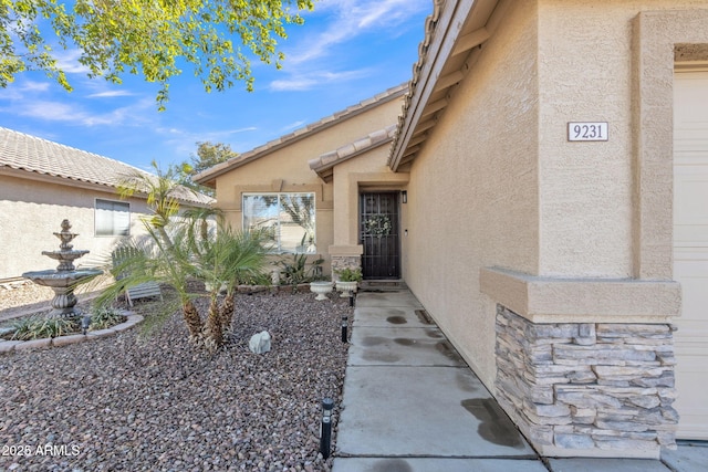 property entrance featuring stucco siding and a tiled roof