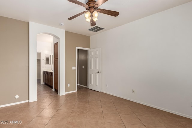 8848 W Cordes Rd, Tolleson, AZ 85353 - unfurnished bedroom featuring arched walkways, light tile patterned flooring, and baseboards